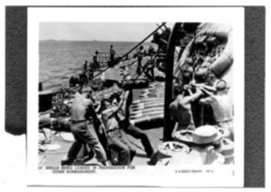 WORLD WAR II: FOURTEEN INCH SHELLS BEING LOADED IN PREPARATION FOR GUAM BOMBARDMENT