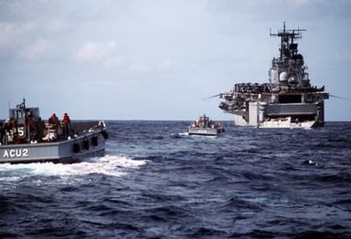 Two LCM-8 mechanized landing craft approach the amphibious assault ship USS SAIPAN (LHA-2) as the utility landing craft LCU-1643 pulls away from the SAIPAN's well deck during Operation Sharp Edge. Marines embarked aboard the SAIPAN are being sent to the U.S. Embassy in Monrovia, Liberia, to augment security and evacuate U.S. and foreign nationals from the fighting between government and rebel forces