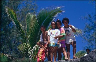 Group of children looking down at the camera from a rocky ridge