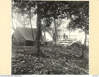 KILIGIA, NEW GUINEA. 1944-04-08. THE GSO I, (INTELLIGENCE), HEADQUARTERS 5TH DIVISION AT PRESENT OCCUPIES THE TENT, BUT WILL BE MOVING TO THE BUILDING UNDER CONSTRUCTION WHICH OVERLOOKS THE PACIFIC ..