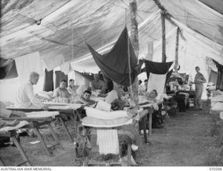 FINSCHHAFEN, NEW GUINEA, 1944-01-31. THE INTERIOR OF WARD 6 AT THE 2/3RD CASUASLTY CLEARING STATION SHOWING THE ROUGH BUT EFFECTIVE CONSTRUCTION OF TARPAULINS OVER BUSH POLES. THE WARD CONTAINS ..