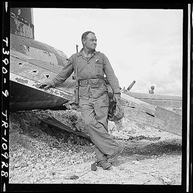 Lt. Paul Dorsey a Marine Corps photographer attached to Comndr. Edward Steichen's Naval Aviation Photographic Unit is standing beside a wrecked Jap plane on Guam.