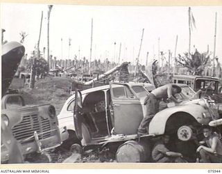 HANSA BAY AREA, NEW GUINEA. 1944-09-07. CIVILIAN TYPE SEDAN CARS WHICH WERE USED BY THE JAPANESE ARMY BEING STRIPPED OF ANY VALUABLE PARTS BY MEMBERS OF THE 5TH DIVISION SALVAGE UNIT