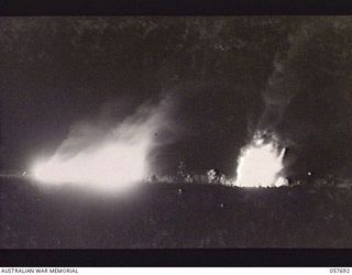 DOBODURA, NEW GUINEA. 1943-10-09. OIL DUMP BLAZING FURIOUSLY IMMEDIATELY AFTER THE JAPANESE AIR RAID ON THE AREA