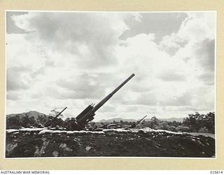 PORT MORESBY, PAPUA. 1942-07. SILHOUETTED AGAINST HEAVY TROPIC CLOUDS, THESE GUNS, MANNED BY AUSTRALIANS WHO SAW ACTION AGAINST GERMAN BOMBERS AT HAIFA, PALESTINE, ARE BEING BROUGHT TO BEAR ON ..