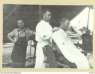 MILILAT, NEW GUINEA. 1944-08-01. THE UNIT BARBER AT WORK IN HIS TENT AT HEADQUARTERS, 5TH DIVISION. THEY ARE:- NX129102 CRAFTSMAN J. ILLINGWORTH (1); QX34314 PRIVATE A. GODFREY (2); QP8384 DRIVER ..