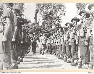 BOUGAINVILLE. 1945-03-31. LORD WAKEHURST, GOVERNOR OF NEW SOUTH WALES (2), WITH THE GUARD COMMANDER, MAJOR W. MCCALL, 57/60 INFANTRY BATTALION (1), INSPECTING THE GUARD OF HONOUR AT PIVA AIRSTRIP, ..