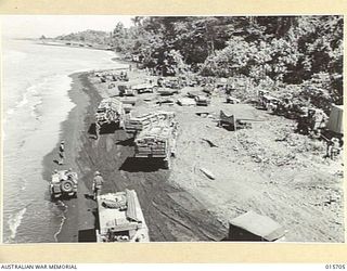 1943-09-15. LAE SALAMAUA ISOLATED. HEAVILY LADEN TRUCKS, JEEPS AND, IN FOREGROUND, AN ARTILLERY TRACTOR AND GUN MOVE FORWARD IN THE WAKE OF THE AUSTRALIANS WHO HAD MOVED INLAND AFTER HAVING LANDED ..