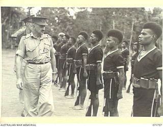 LAE, NEW GUINEA, 1944-03-27. MAJOR-GENERAL B. M. MORRIS, DSO (LEFT), INSPECTS A LOCAL DETACHMENT OF THE ROYAL PAPUAN CONSTABULARY AT THE ROYAL PAPUAN CONSTABULARY BARRACKS DURING A VISIT TO LAE