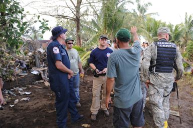 Earthquake ^ Tsunami - Leone, American Samoa, October 2, 2009 -- Chris Reiner, U. S. Environmental Protection Agency and Troy Utley, U. S. Coast Guard, discuss hazardous waste removal with a survivor of the tsunami in American Samoa The containment of hazardous waste is an important step in the removal of debris after a tsunami disaster.