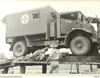 LAE, NEW GUINEA. 1944-11-18. NX102755 LIEUTENANT J.C. SELWOOD, TRANSPORT OFFICER, 18TH FIELD AMBULANCE (2) SUPERVISING THE SERVICING OF A UNIT AMBULANCE BY PRIVATE J.W. ELLIOTT (1) AND PRIVATE K.C. ..