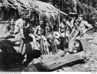 1943-09-20. NEW GUINEA. BUSO RIVER - LAE AREA. AUSTRALIAN TROOPS WITH NATIVE POLICE BOYS IN THE VILLAGE OF BUSO. (NEGATIVE BY H. DICK)