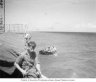 Scientists going out to net dead fish while B. Bosing tends the line for divers, Bikini Atoll, 1947