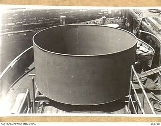 SYDNEY, NSW. 1944-01-22. A GUN NEST FOR A 20MM CANNON IN THE PROCESS OF BEING FITTED AMIDSHIPS IN THE MV "FRANCES PEAT" BEFORE THE SHIP IS PUT INTO SERVICE WITH THE AUSTRALIAN SMALL SHIPS SECTION ..