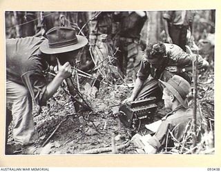 WEWAK AREA, NEW GUINEA. 1945-06-27. CAPTAIN J.S. ADAMS, ADJUTANT, 2/8 INFANTRY BATTALION, (1), ON THE PHONE TO BRIGADE HEADQUARTERS AT A FORWARD COMMAND POST AT MIDDLE KNOLL, DURING THE ATTACK ..