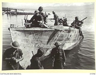 1943-09-22. NEW GUINEA. AUSTRALIAN TROOPS CAPTURE LAE. WRECKED JAPANESE BARGES ALONG THE WATERFRONT WERE SEARCHED SOON AFTER THE AUSTRALIAN TROOPS ENTER LAE