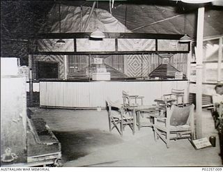 Madang, New Guinea, 1945. Interior of the Officers' Mess at Headquarters, RAAF Northern Command (NORCOM). Tables and chairs are set out under electric lights in the mess, while standing in the ..