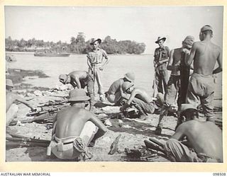 NAMATANAI, NEW IRELAND. 1945-10-29. JAPANESE WORKING PARTY TAKING BOLTS OUT OF RIFLES BEFORE THEY ARE DUMPED IN THE SEA. TROOPS OF 11 INFANTRY BATTALION, 13 INFANTRY BRIGADE, ARE SUPERVISING THE ..