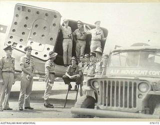 FINSCHHAFEN, NEW GUINEA. 1944-09-20. PERSONNEL OF THE 8TH MOVEMENT CONTROL GROUP, (DRAGER DETACHMENT), MEETING AN AUSTRALIAN NATIONAL AIRWAYS AIRCRAFT MARKED WITH UNITED STATES ARMY AIR FORCE ..