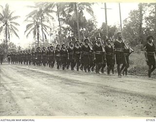 MILNE BAY, PAPUA, NEW GUINEA. 1944-04-01. MEMBERS OF THE ROYAL PAPUAN CONSTABULARY IN THE SAMARAI DISTRICT MARCHING WITH RIFLES AT THE SLOPE DURING A PARADE