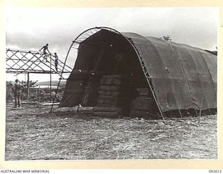 CAPE WOM, NEW GUINEA. 1945-05-29. A PORTABLE STEEL FRAME AND CANVAS "TENT SHELTER" IN USE AT THE ASSISTANT DIRECTOR OF ORDNANCE SERVICE DEPOT AS A TEMPORARY HOUSE FOR ORDNANCE SUPPLIES. IN THE ..