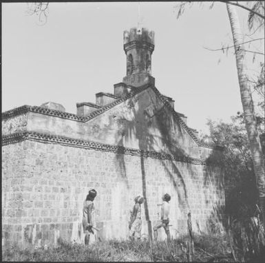 Three people looking at Château d'eau à Ouro, Isle of Pines, New Caledonia, 1967 / Michael Terry