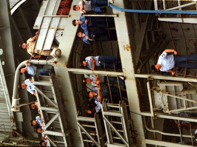 Sailors of the submarine tender USS HOLLAND (AS-32) line the rails as the ship prepares to dock after 45 days at sea