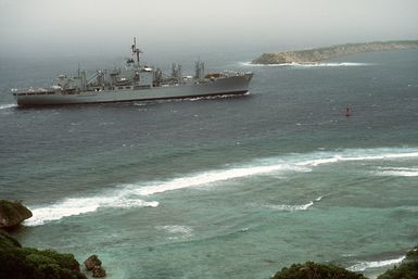 Starboard side view of the combat stores ship USS NIAGARA FALLS (AFS 3) passing the man-made Glas Breakwater while en route to Naval Station Guam