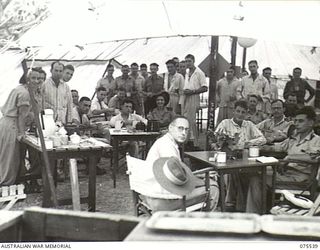 MADANG, NEW GUINEA. 1944-08-25. PATIENTS AND VISITORS ENJOYING MORNING REST IN THE TENT OF THE 2/11TH AUSTRALIAN RED CROSS SOCIETY