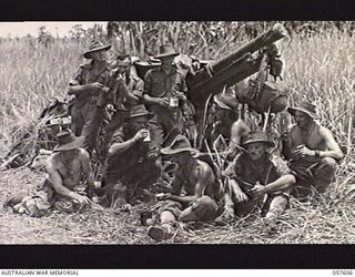 SALAMAUA AREA, NEW GUINEA. 1943-09-26. MEN OF THE 54TH BATTERY, 2/4TH AUSTRALIAN FIELD REGIMENT ENJOY A CUP OF TEA IN THE KUNAI GRASS NEAR THEIR 25-POUNDER GUN