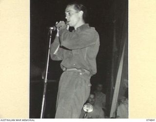 LAE, NEW GUINEA. 1944-07-24. ONE OF THE SUPPORTING PERFORMERS DOING A TURN DURING A CONCERT STAGED FOR THE TROOPS BY THE JACK BENNY SHOW