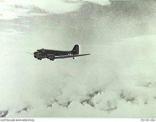 C. 1942. THE 5TH AIR FORCE (USAAF) C47 TRANSPORT AIRCRAFT "IRENE" FLYING SOMEWHERE OVER NEW GUINEA. THIS AIRCRAFT WAS AMONG THE FIRST ALLIED TRANSPORT AIRCRAFT TO DROP SUPPLIES TO AUSTRALIAN TROOPS ..