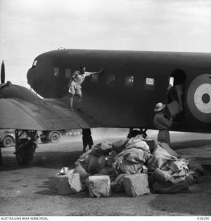 PAPUA, NEW GUINEA. 1942-08. LOADING SUPPLIES ON TO A TRANSPORT PLANE FOR DROPPING TO TROOPS IN THE FORWARD AREA