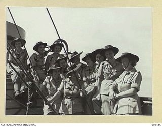 LAE, NEW GUINEA, 1945-05-07. A GROUP OF AUSTRALIAN WOMEN'S ARMY SERVICE ON THE RAIL OF THE MV DUNTROON, BEFORE DISEMBARKATION. THEY ARE EN ROUTE TO THE AUSTRALIAN WOMEN'S ARMY SERVICE BARRACKS AT ..