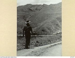 FINISTERRE RANGES, NEW GUINEA, 1944-03-15. VX108008 LIEUTENANT I.G. BENNETT, COMMANDING NO.2 PLATOON, 2/4TH FIELD COMPANY, ON AN INSPECTION ALONG THE ROAD AT THE FOOTHILLS OF THE FINISTERRE RANGES ..