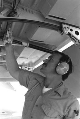 A non-commissioned officer of a Naval Air Reserve Patrol Squadron 64 (VP-64) P-3 Orion aircraft works under the aircraft during active duty training