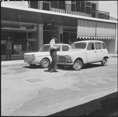 Policeman booking a car outside Qantas office, Noumea, New Caledonia, 1967 / Michael Terry