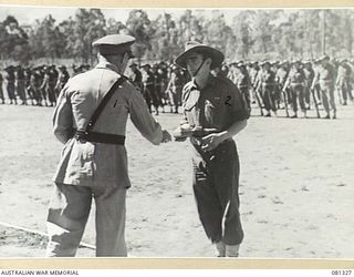 HERBERTON, QLD. 1944-10-11. VX17 MAJOR GENERAL J.E.S. STEVENS, DSO, ED, GOC 6TH DIVISION (1) PRESENTS THE ORDER OF PATRIOTIC WAR FIRST CLASS TO NX4050 SERGEANT N.S. MACINTRYE (2). MEMBERS OF THE 2/ ..