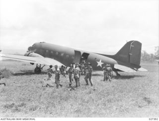 WANIGELA, NEW GUINEA. 1942-10. MEMBERS OF THE 2/6TH AUSTRALIAN INDEPENDENT COMPANY A.I.F., ALIGHTING FROM A 5TH US ARMY AIR FORCE (USAAF) C-47 TRANSPORT PLANE ON A ROUGH RUNWAY ON THE SHORES OF ..