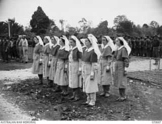 FINSCHHAFEN, NEW GUINEA, 1944-02-29. TWELVE SISTERS OF THE AUSTRALIAN ARMY NURSING SERVICE, REPRESENTING NURSING UNITS IN THE AREA, FACING THE MEMORIAL DURING THE OFFICIAL OPENING OF THE ..