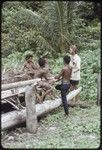 Edwin Hutchins converses with adolescent boys by a large canoe