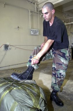 US Air Force (USAF) STAFF Sergeant (SSGT) John Rizzo from the 7th Expeditionary Maintenance Squadron (EMXS), packs parachute cords to a B-52 Stratofortress bomber drag-chute, at Andersen Air Force Base (AFB), Guam