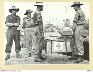 NORTH ALEXISHAFEN, NEW GUINEA. 1944-08-18. VX41865 SERGEANT G.A. IBBOTT (1) AND NX89566 PRIVATE C.S. HETHERINGTON (2) BOTH OF THE 111TH CASUALTY CLEARING STATION, LOADING MEDICAL STORES ABOARD THE ..