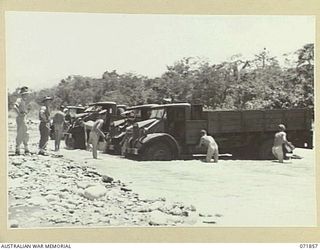 LAE, NEW GUINEA. 1944-03-30. DRIVERS OF THE 151ST GENERAL TRANSPORT COMPANY WASHING VEHICLES IN THE BUSU RIVER. DESPITE A FLOW AT APPROXIMATELY TEN KNOTS, THE RIVER HAS BEEN A BOON TO THE COMPANY ..