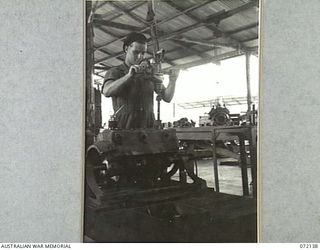 PORT MORESBY, NEW GUINEA. 1944-04-10. VX143788 CRAFTSMAN R.G. WESTLEY USING EQUIPMENT TO POLISH THE INNER SURFACE OF AN ENGINE BLOCK AT THE 11TH ADVANCED WORKSHOP, AUSTRALIAN ELECTRICAL AND ..