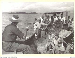 MOILA POINT, BOUGAINVILLE. 1945-09-28. LIEUTENANT T.H. LIPSCOMBE, ALLIED TRANSLATOR AND INTERPRETER SERVICE, INTERROGATING JAPANESE ON A BARGE CARRYING THE LAST BATCH OF TROOPS FROM TONOLEI HARBOUR ..