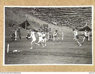 DONADABU, PAPUA, NEW GUINEA. 1944-01-01. THE BATON CHANGE OVER AT THE 330 YARDS POINT DURING THE 440 YARDS RELAY RACE AT THE 15TH INFANTRY BRIGADE GYMKHANA. IDENTIFIED PERSONNEL ARE: PRIVATE B. ..