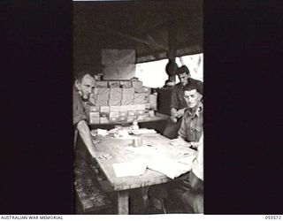 PORT MORESBY, NEW GUINEA. 1943-08-05. CHECKING PARCELS OF ELECTION BALLOT PAPERS FOR DESPATCH TO FORWARD AREAS. LEFT TO RIGHT:- NX66508 LIEUTENANT J. C. MOORE, DEPUTY RETURNING OFFICER FOR NEW ..