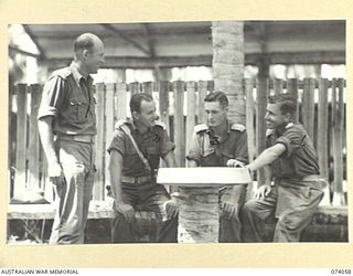SIAR, NEW GUINEA. 1944-06-20. OFFICERS OF B COMPANY, 58/59TH INFANTRY BATTALION, CHATTING OUTSIDE THE OFFICER'S MESS. IDENTIFIED PERSONNEL ARE:- VX115588 LIEUTENANT A.B. BALL (1); VX104470 ..