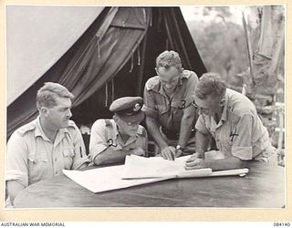 WUNUNG PLANTATION, JACQUINOT BAY, NEW BRITAIN. 1944-12-08. OFFICERS CHECKING MAP REPORTS AT HQ ALLIED INTELLIGENCE BUREAU. IDENTIFIED PERSONNEL ARE:- LIEUTENANT C.K. JOHNSON, ALLIED INTELLIGENCE ..